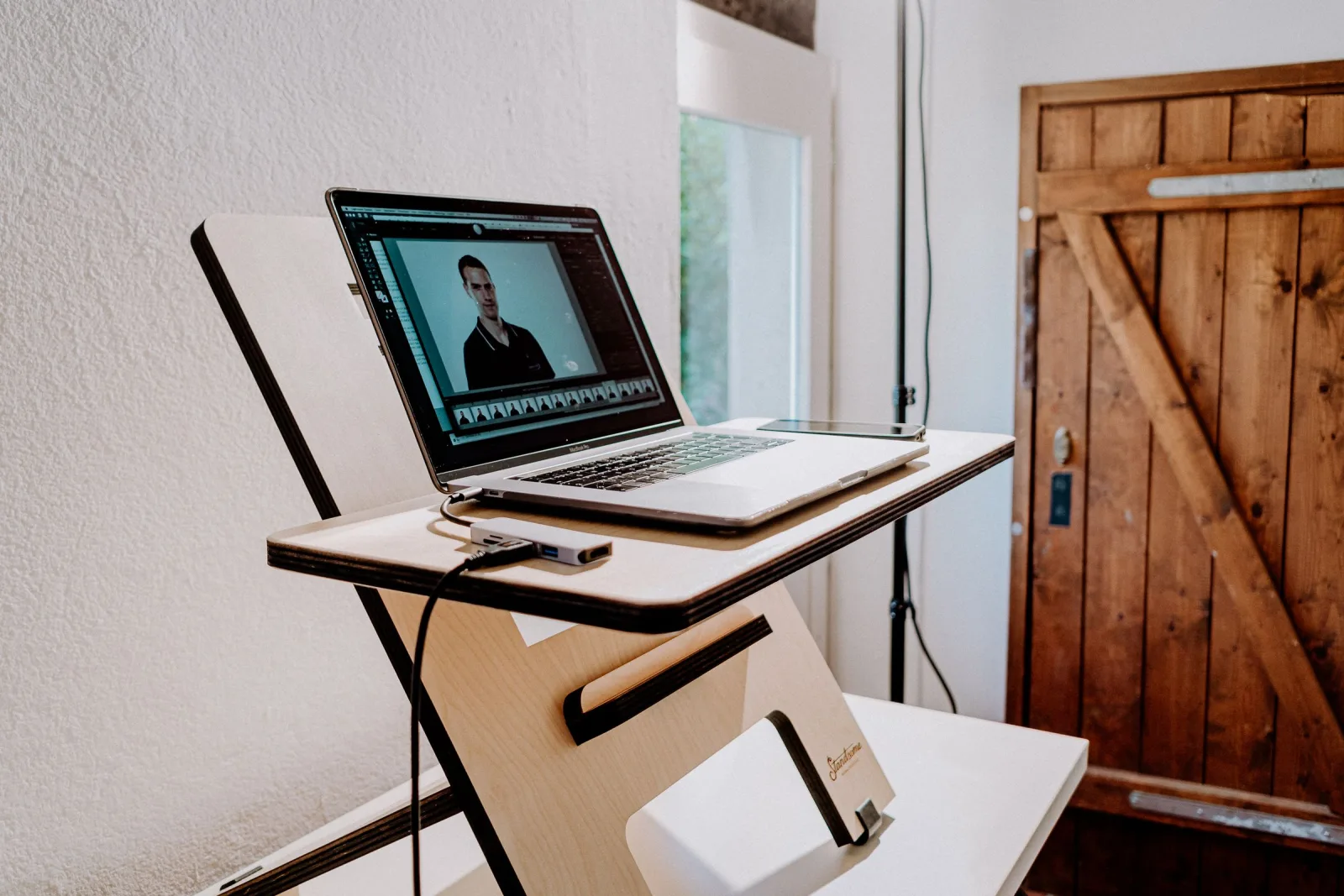 Een laptop op een zelfgebouwd bureau van multiplex, bij daglicht